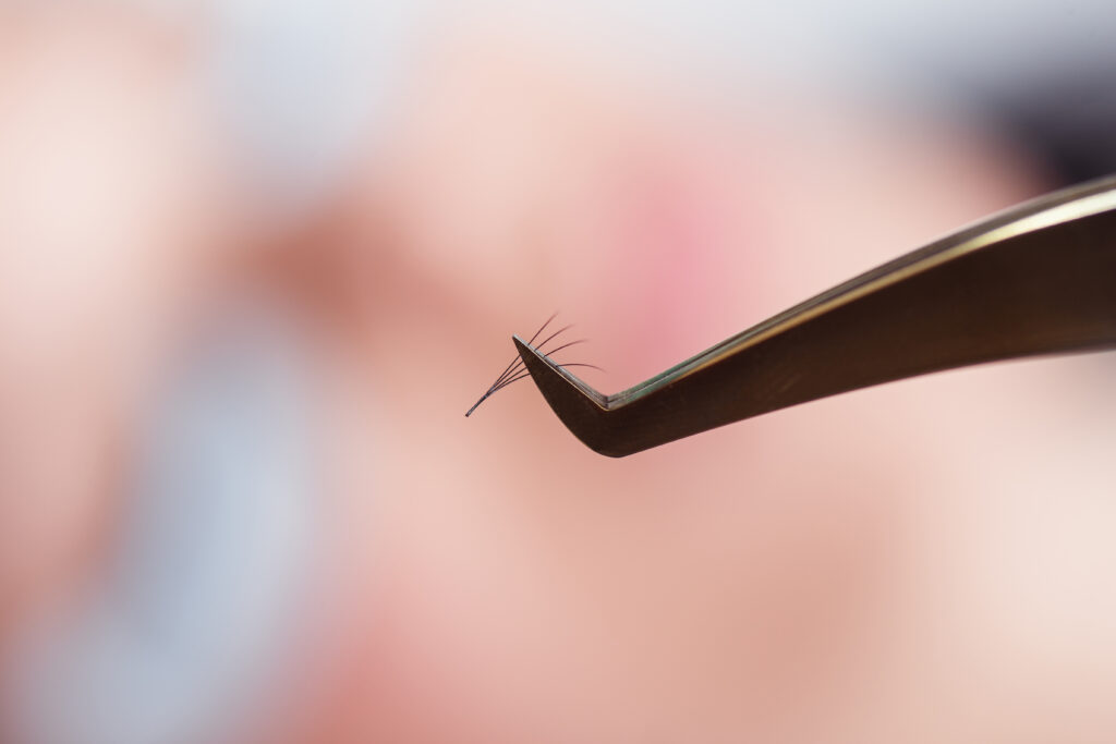 An individual lash being showcased with tweezers.