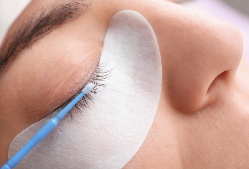 Young woman undergoing eyelash extensions procedure