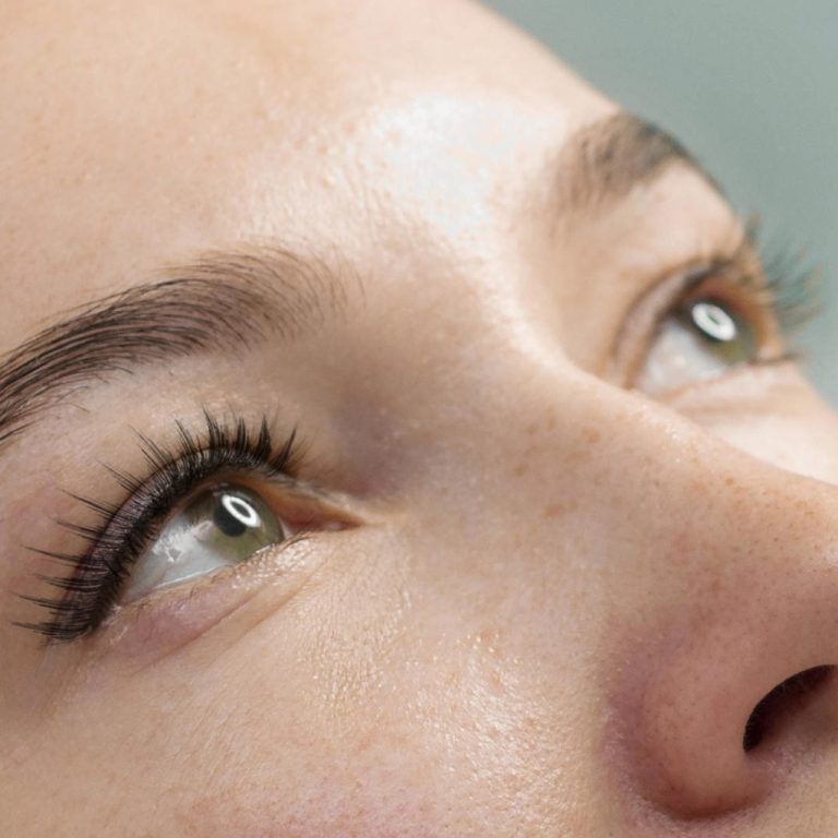 A woman with green eyes with natural looking eyelash extensions